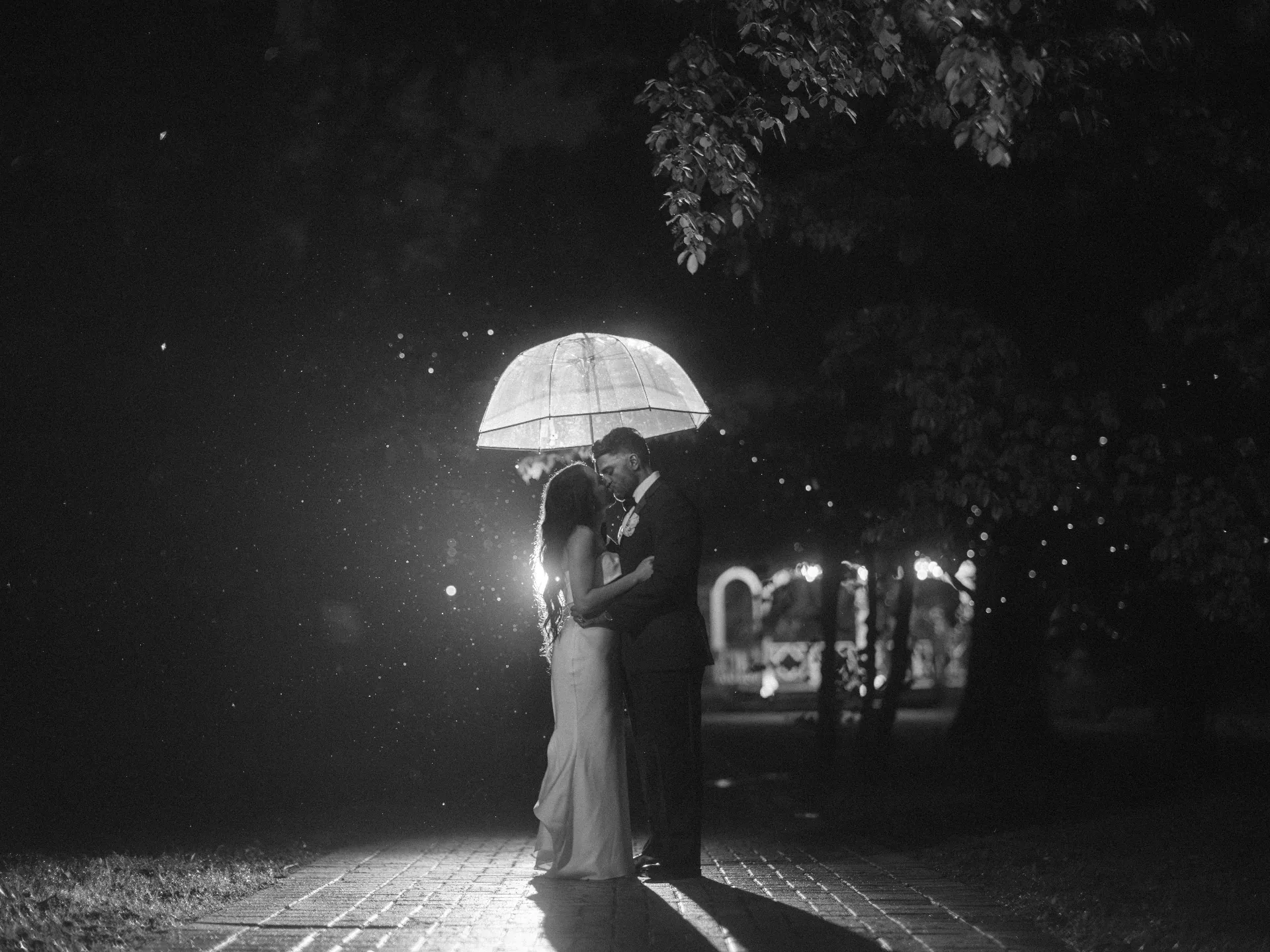 Couple under a clear umbrella in the rain at night