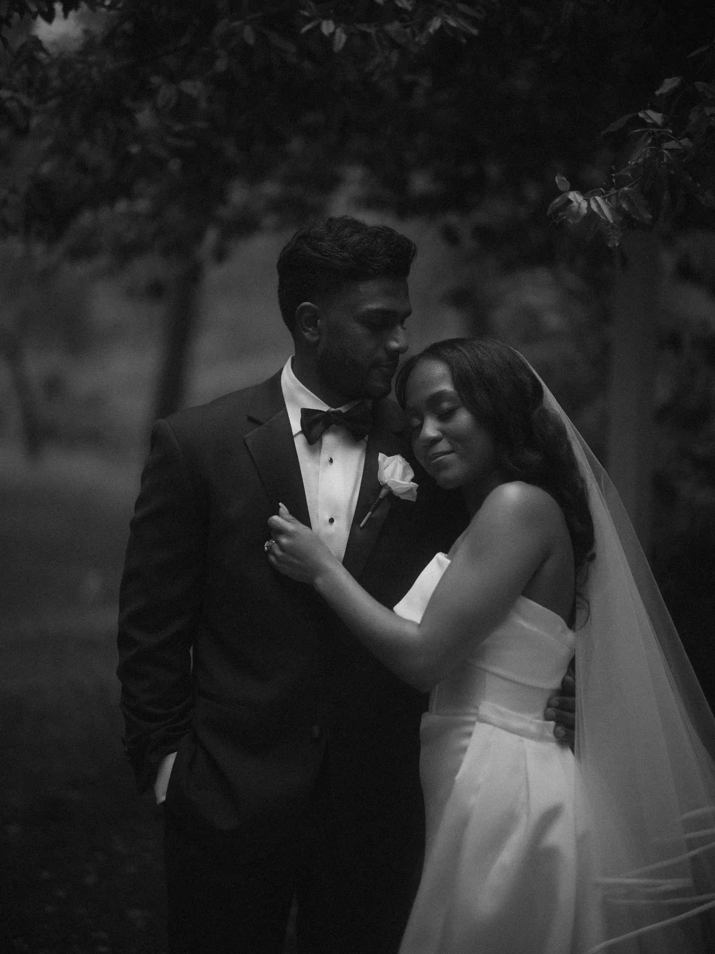 Groom kissing the bride's head, in black and white