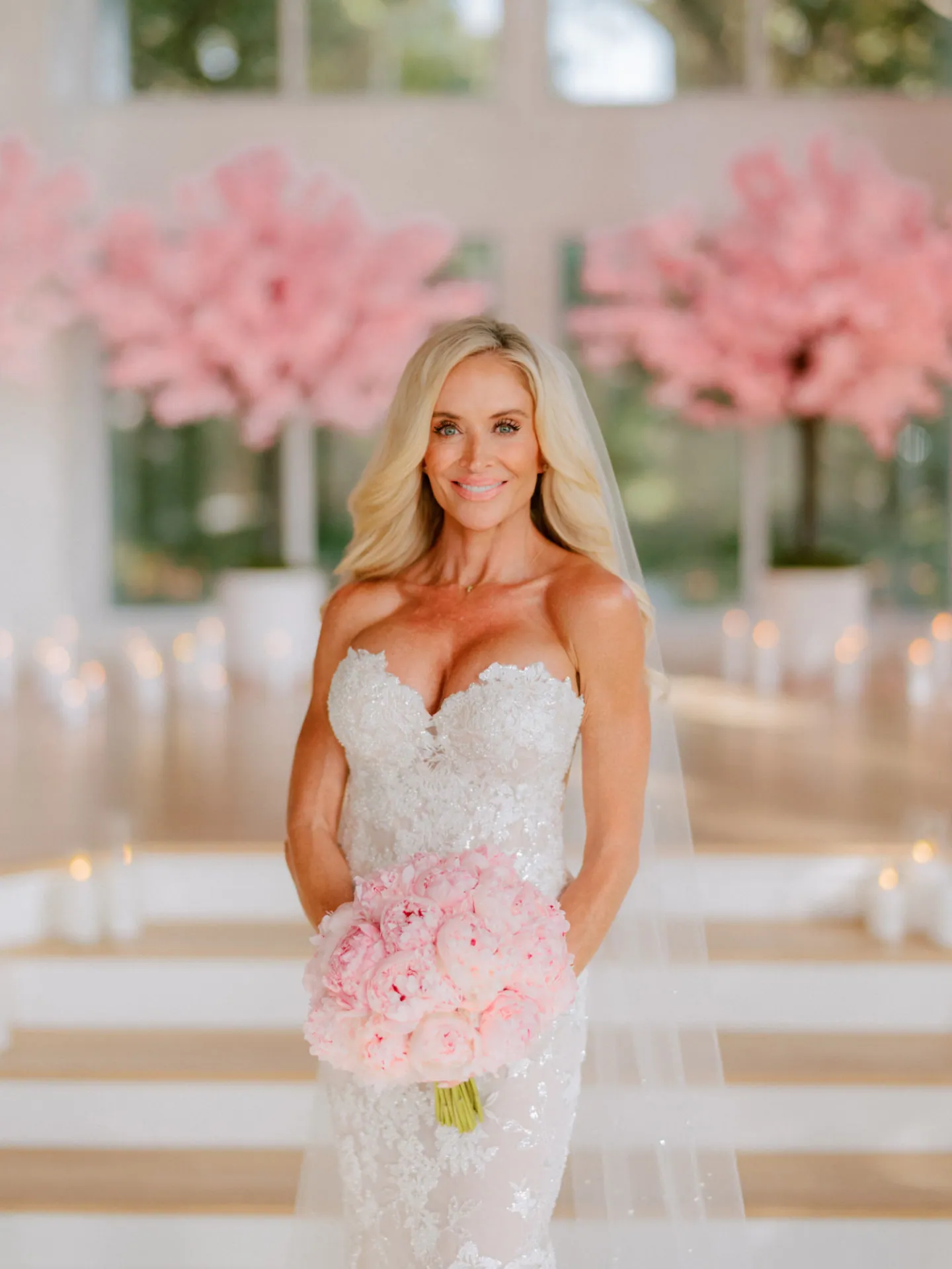 Bride with a peony bouquet in a bright chapel with blossom trees