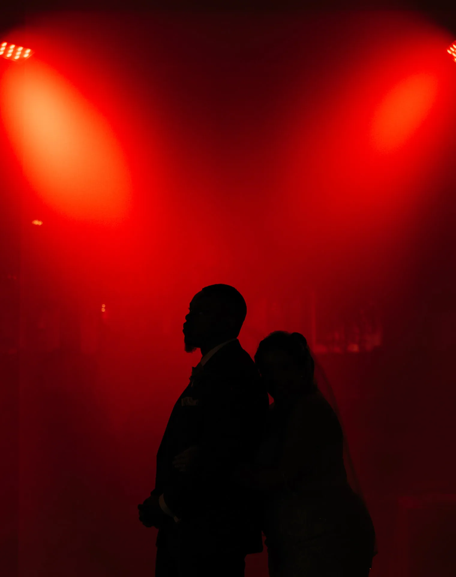 Couple silhouetted against deep red reception lighting